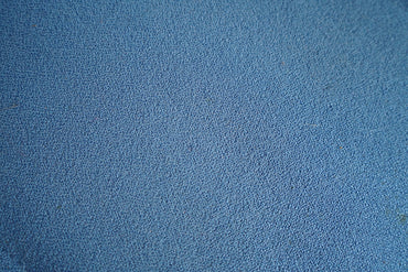 Close-up af blå polstring og detaljer på kontorstol med høj ryg og ergonomisk design.