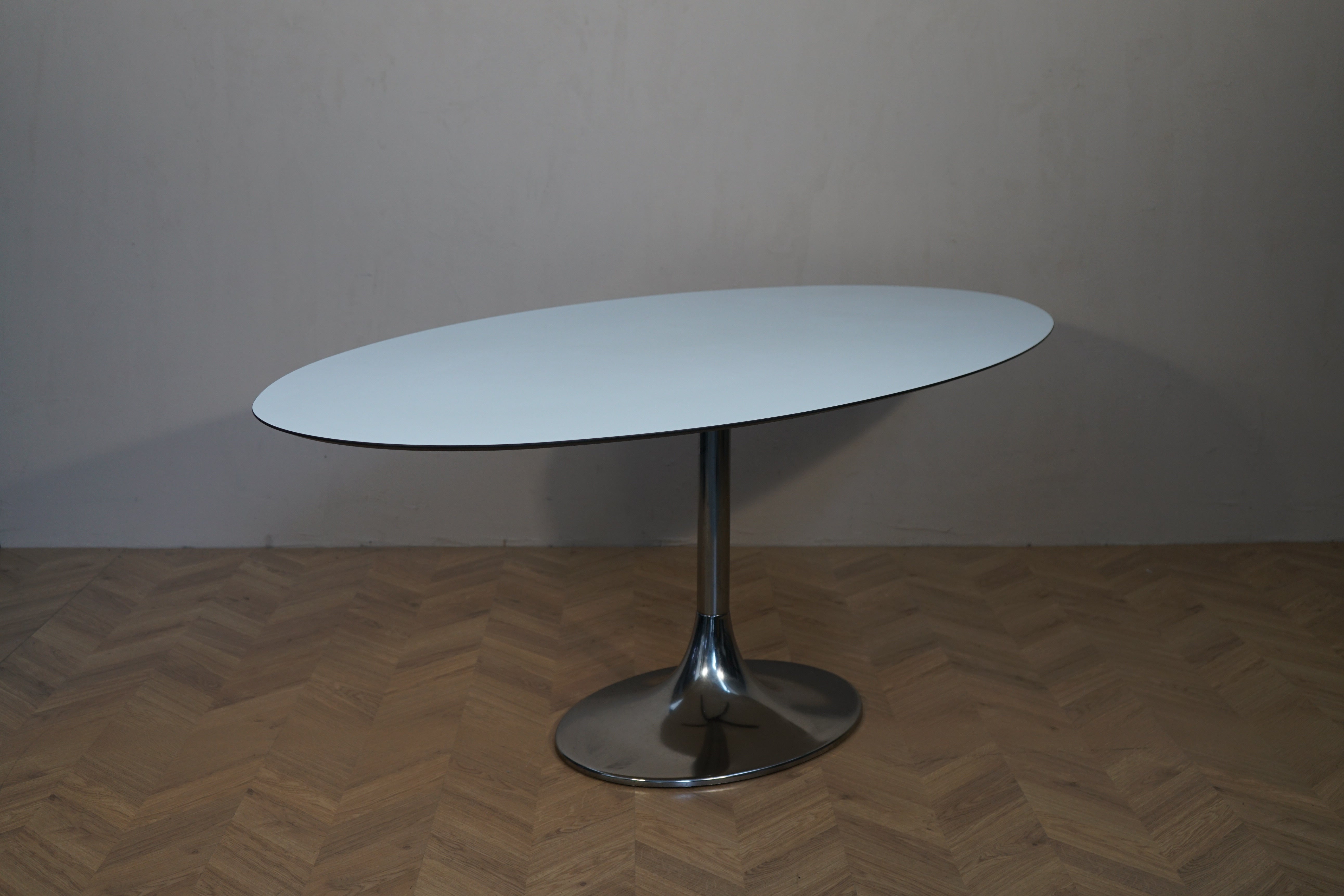 Bolia Corona ovalt møde- og spisebord i hvid laminat med aluminiumsbase set fra skrå vinkel.