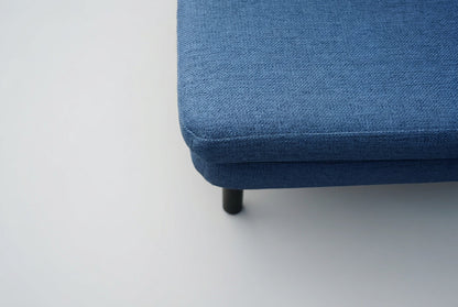 Nærbillede af Bolia samtalesofa med blå polstring og afrundede armlæn i moderne skandinavisk design.