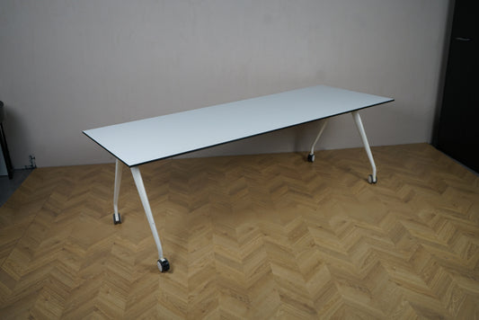 Bono mødebord 220x80 cm med hvid bordplade og hjul set fra skrå vinkel