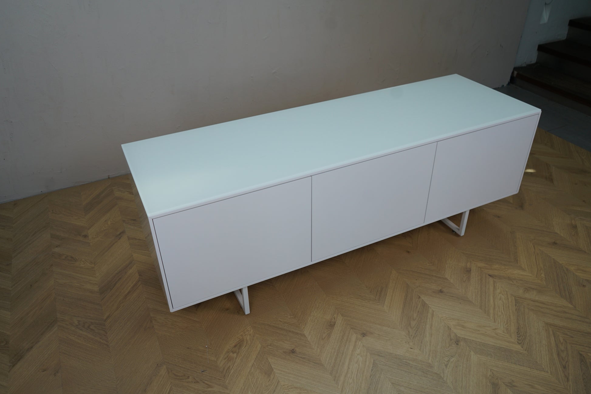 Hvid skænk i minimalistisk design set skråt ovenfra – 158x50x58 cm brugt kontormøbel