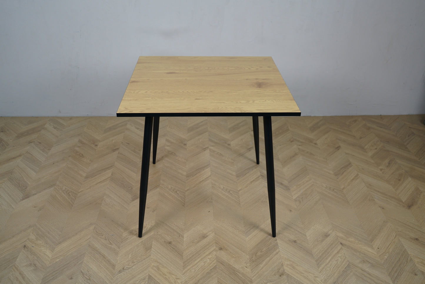 Carnett spisebord 140x80 cm set forfra – stilrent bord med grå trælook bordplade og sort stel.