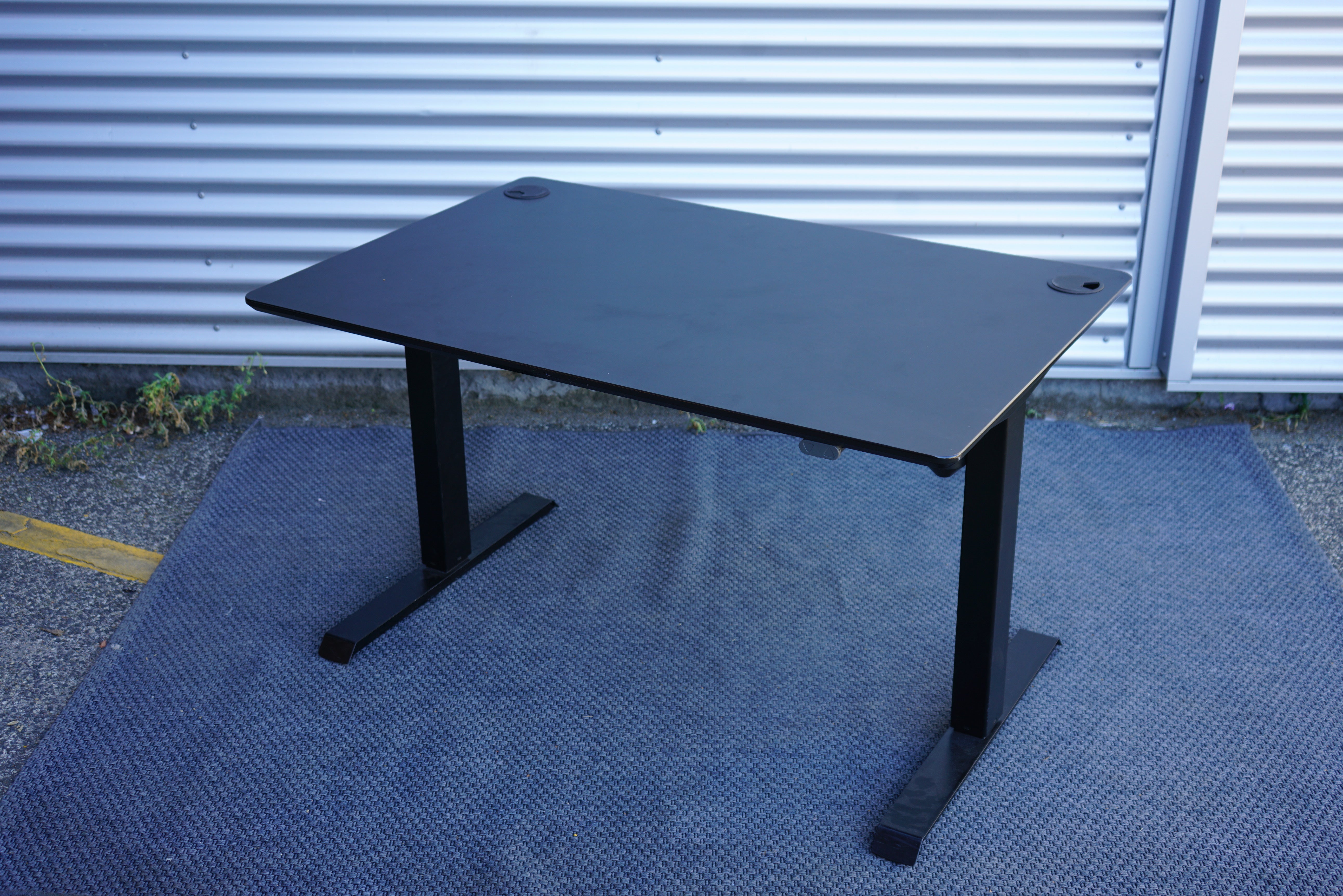 Conset hæve-sænkebord 120x80 i sort laminat med sort stel set fra skrå vinkel