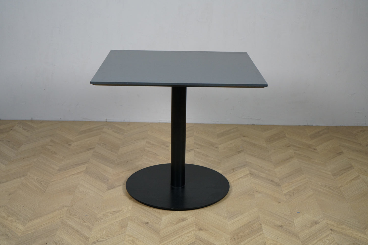 Cube Design cafébord i mørkegrå laminat med sort metalstel set forfra