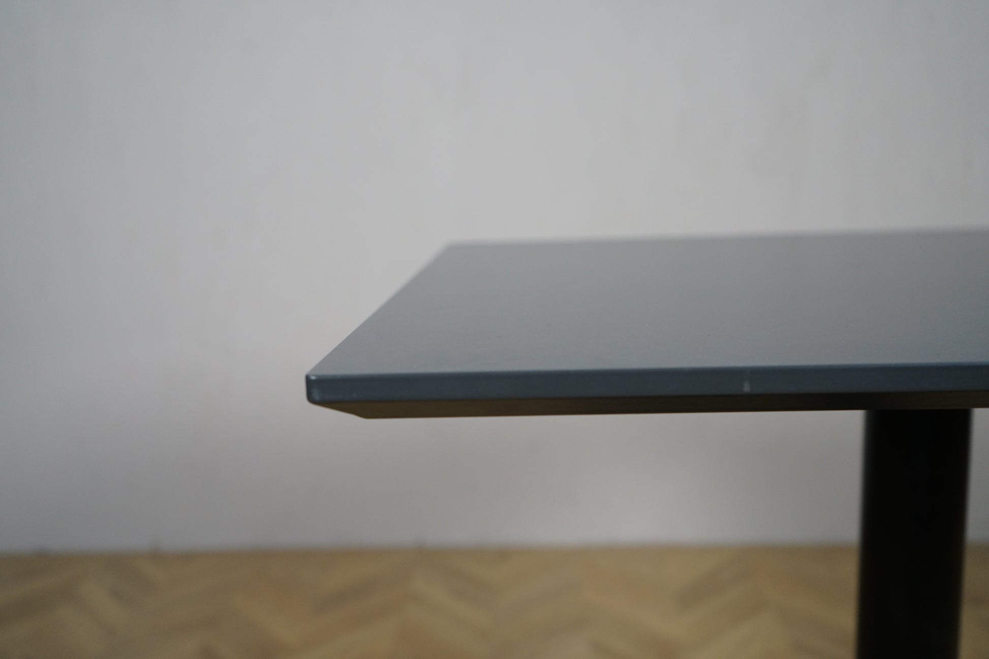 Close up af Cube Design cafébord med mørkegrå laminat bordplade og affaset kant