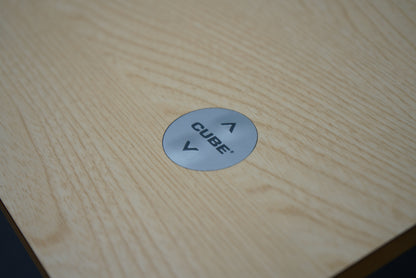Nærbillede af betjeningsknap til Cube Design hæve-sænkebord i egetræ med op- og ned-funktion.