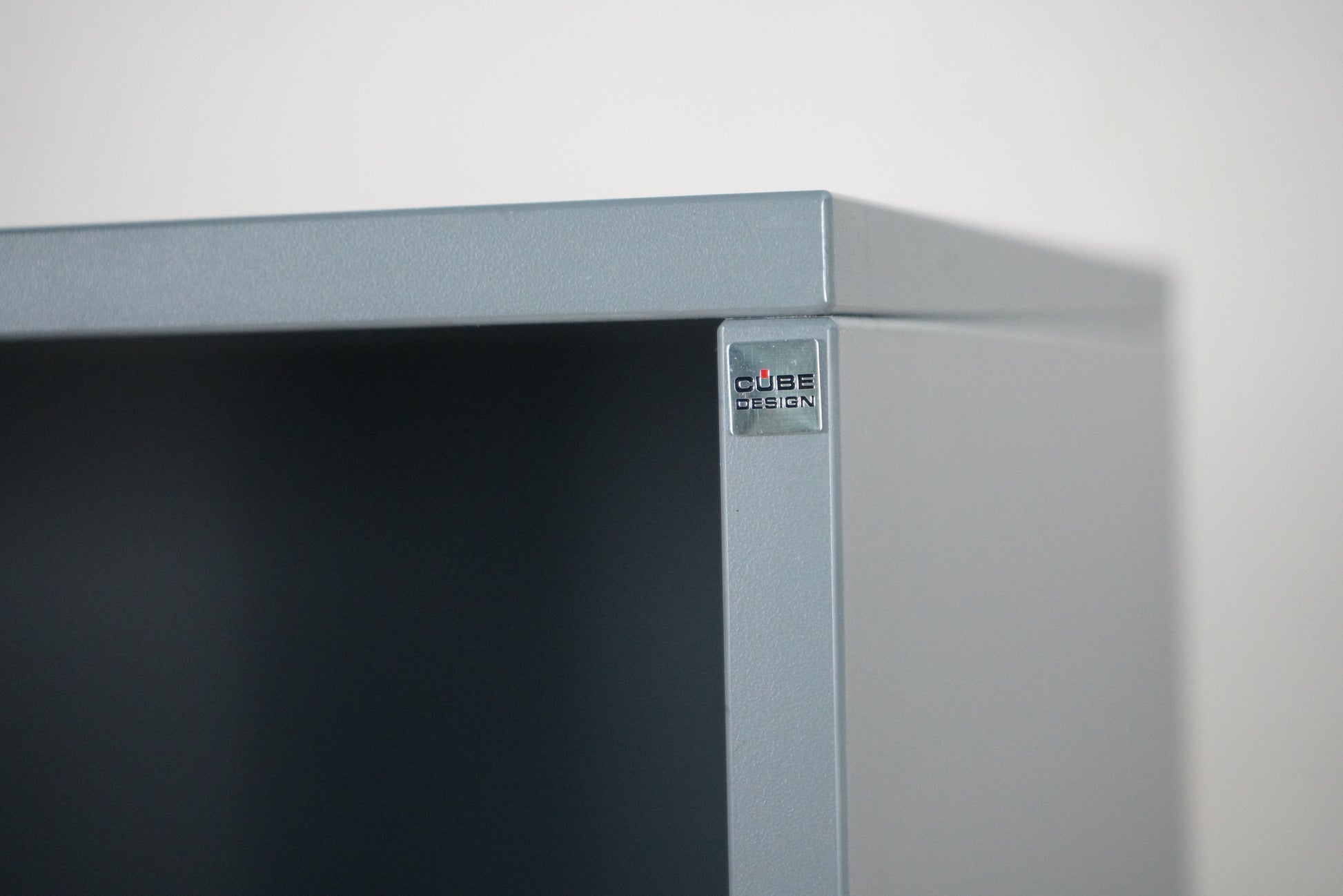 Cube Design logo på antracitgrå høj reol