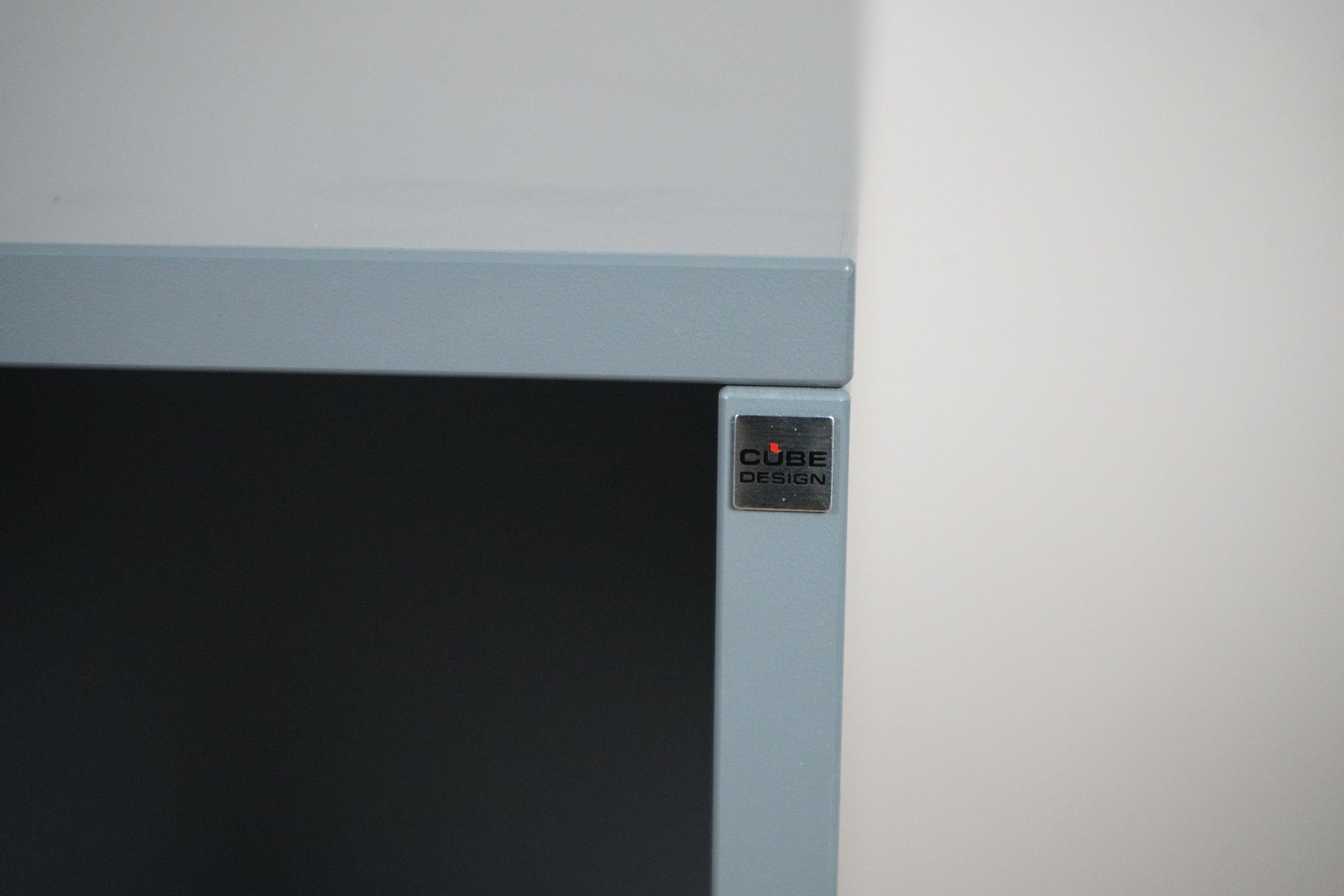 Cube Design logo på antracitgrå reol