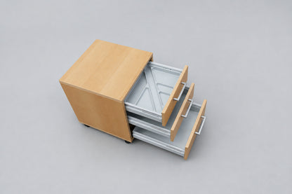 Cube Design skuffedarium i ahornfinér med åben skuffe og sorte hjul set skråt