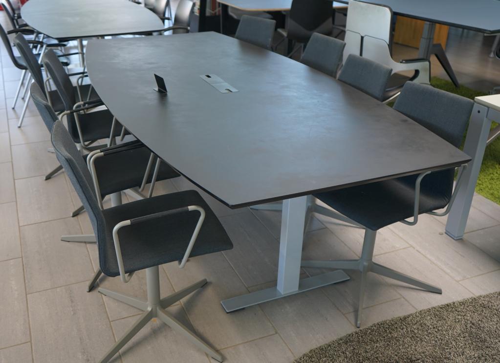 Skrå visning af Dencon Delta konferencebord med tøndeformet sort nanolaminat bordplade og kabelgennemføring – 240x120 cm.