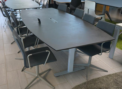 Skrå visning af Dencon Delta konferencebord med tøndeformet sort nanolaminat bordplade og kabelgennemføring – 240x120 cm.