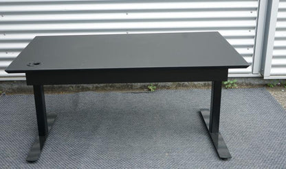 Dencon hæve-sænkebord 130x80 set bagfra med kabelbakke og sort understel.