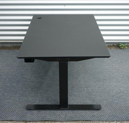 Sideprofil af Dencon hæve-sænkebord 130x80 med sort linoleum bordplade og sort understel.