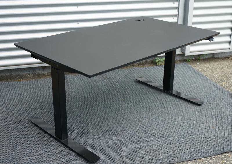 Dencon hæve-sænkebord 130x80 med sort linoleum bordplade og sort understel set fra skrå vinkel.