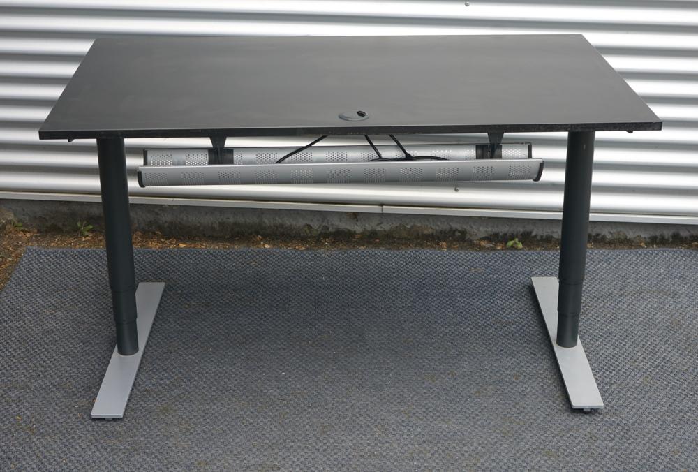 Bagfra visning af Dencon hæve-sænkebord 140x80 cm i sort med kabelgennemføring og robust stel.