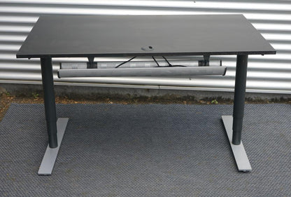 Bagfra visning af Dencon hæve-sænkebord 140x80 cm i sort med kabelgennemføring og robust stel.