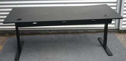 Dencon hæve-sænkebord 160x90 i sort linoleum set bagfra med kabelbakker og robust understel.