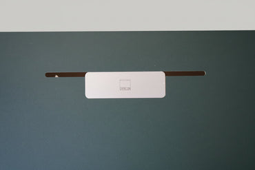 Close up af grøn linoleum bordplade med sort affaset kant på Dencon hæve-sænkebord