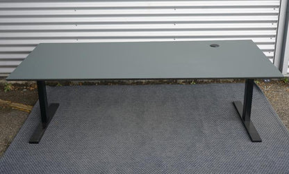 Dencon hæve-sænkebord i mørkegrå linoleum set forfra. Elektrisk højdejusterbart bord med kabelgennemføring og sort kabelbakke, mål 200x90 cm.
