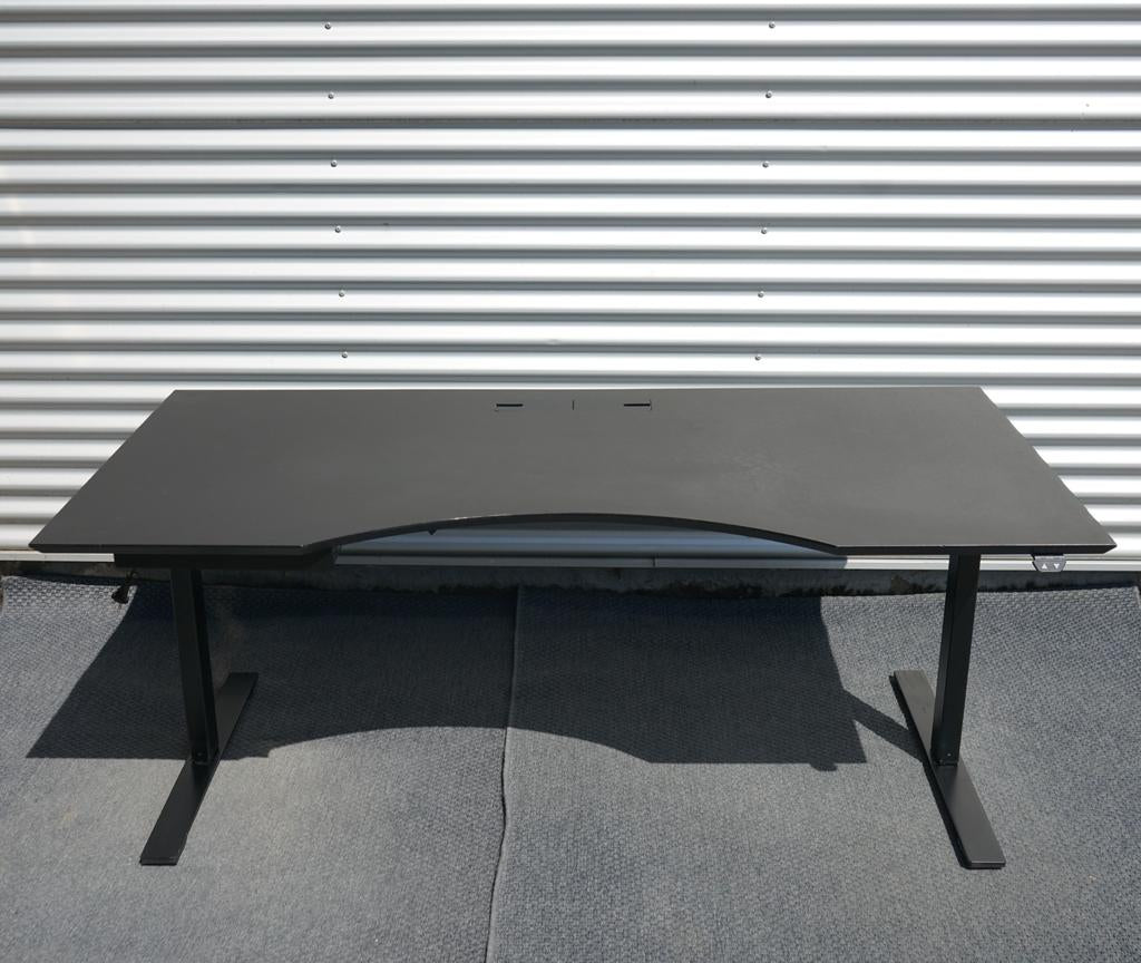 Dencon hæve-sænkebord i sort med linoleumsbordplade og elegant mavebue, set forfra. Elektrisk højdejusterbart bord 180x90 cm med kabelgennemføring.