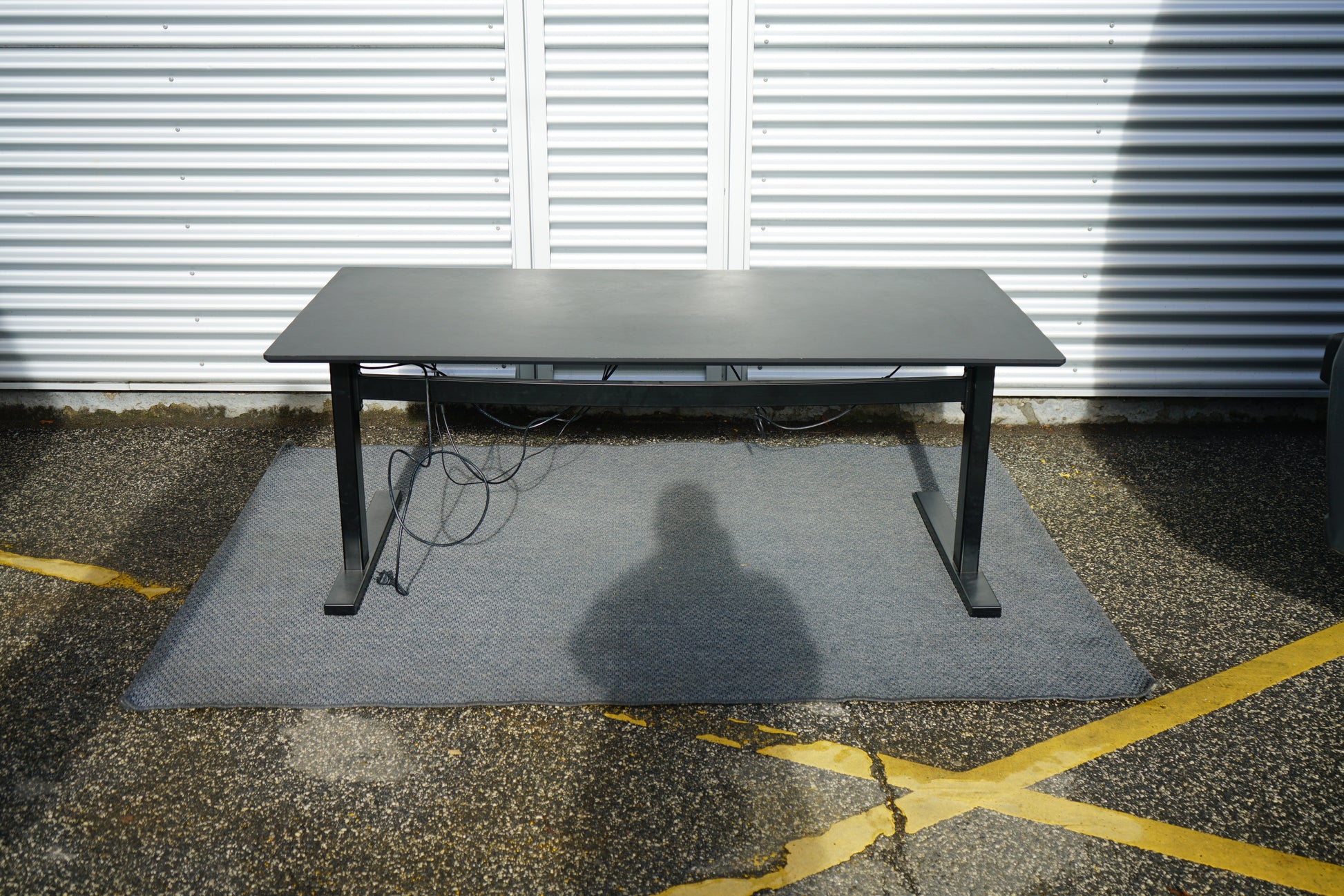 Dencon hæve-sænkebord set fra siden – moderne sort design.