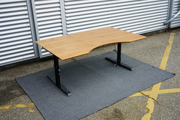 Dencon hæve-sænkebord valnød finér set fra skrå vinkel – moderne kontorbord med mavebue