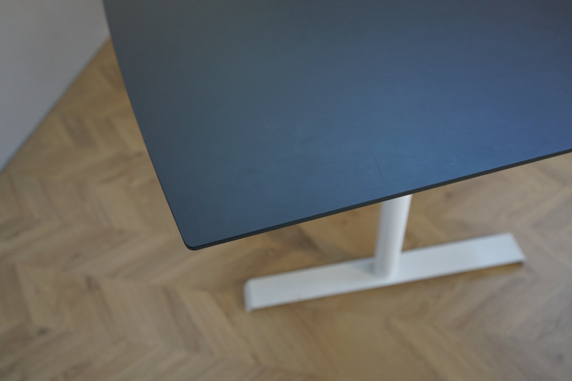 Dencon mødebord i sort linoleum set i skrå vinkel med hvidt stel