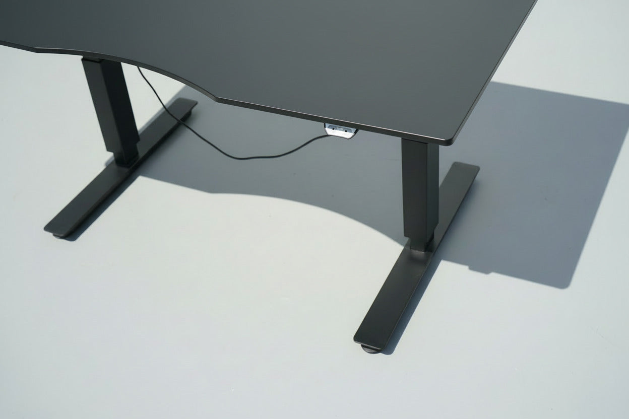 Close up af EFG hæve-sænkebord med sort linoleumsbordplade, ergonomisk mavebue og eksklusiv overflade.