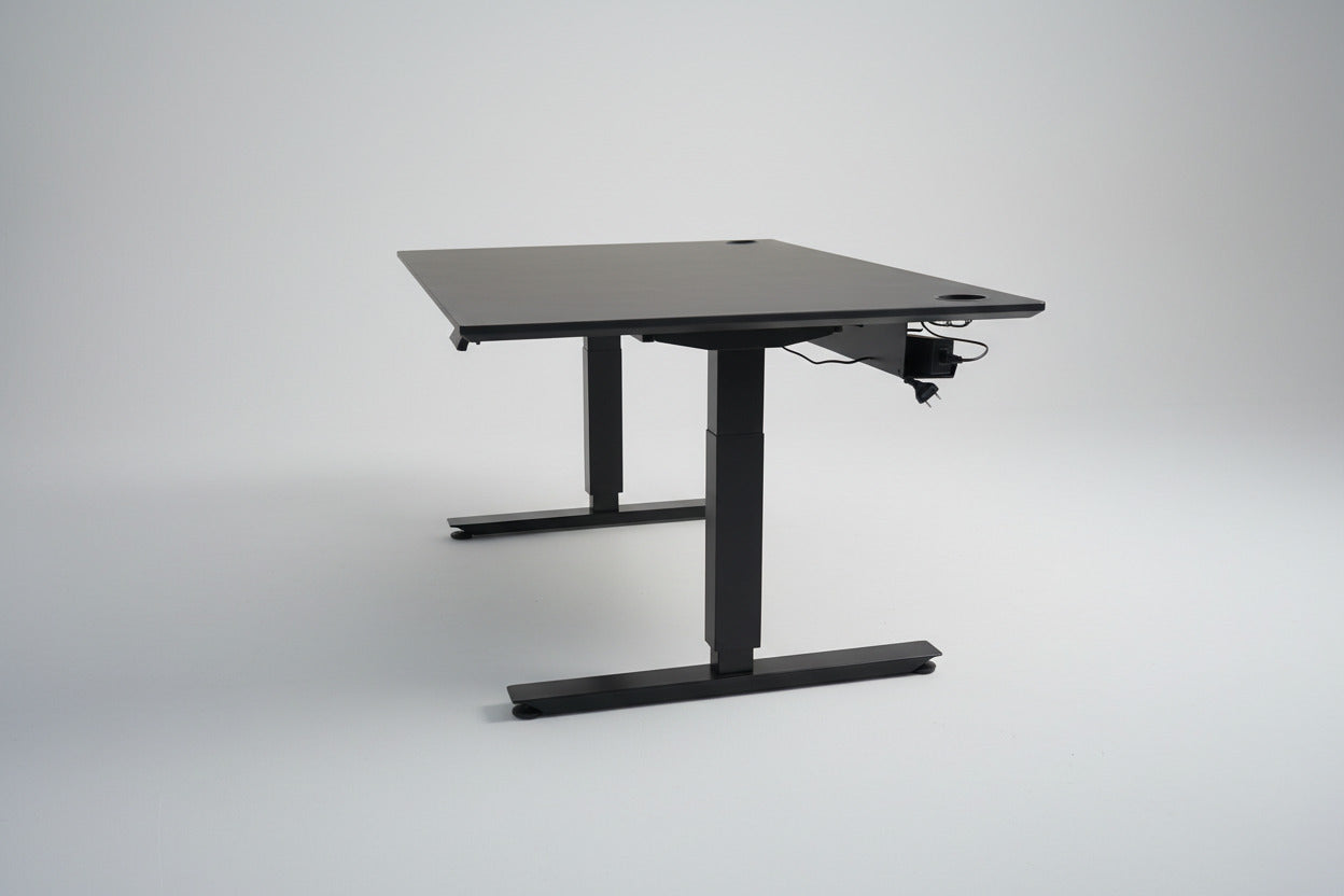 EFG hæve-sænkebord 160x90 cm set fra siden med sort linoleumsbordplade, sort stel og integreret sort kabelbakke.