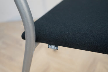 Close up af sort polstret sæde og stel på EFG mødestol