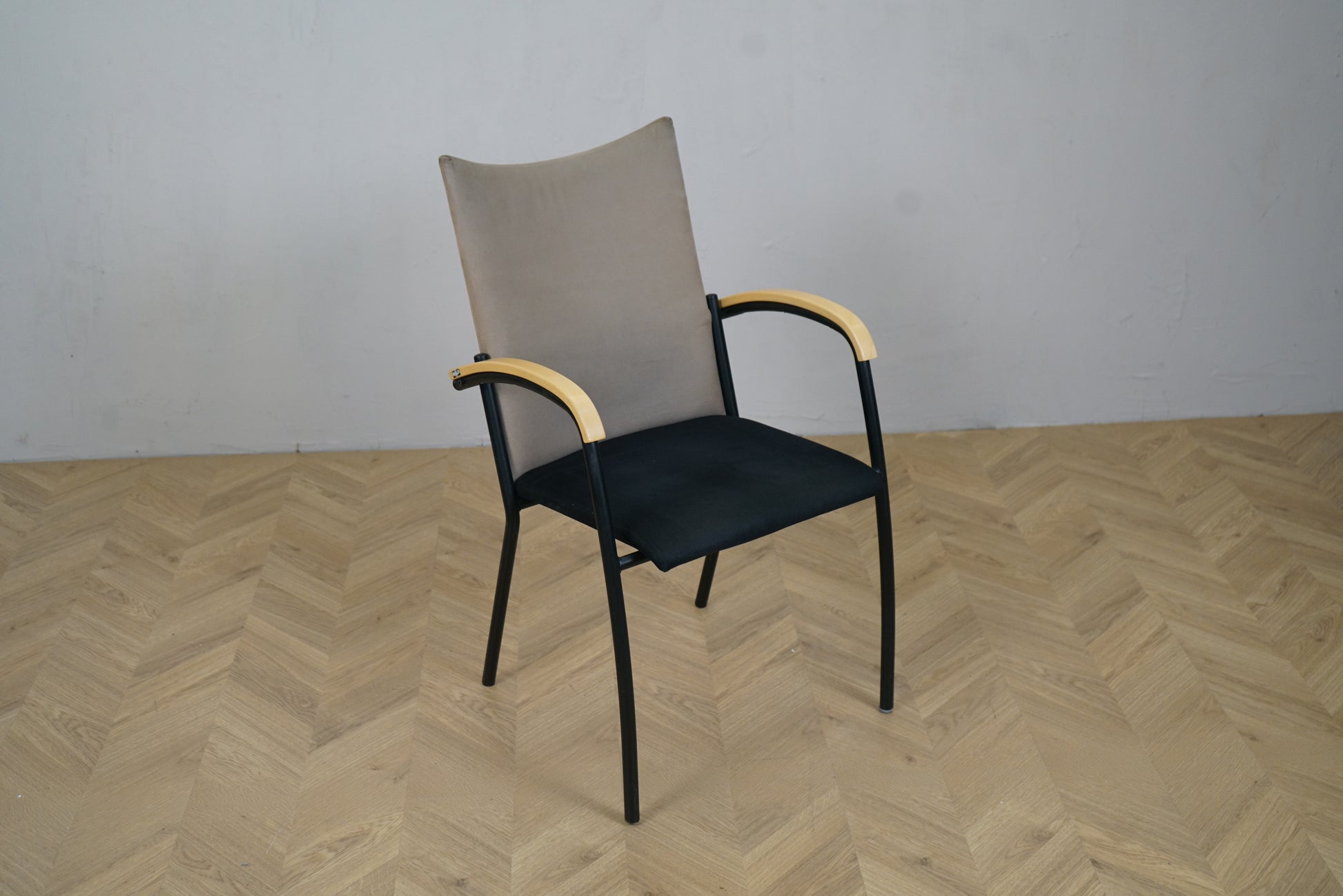 EFG konferencestol i sort og beige med armlæn i træ set fra skrå vinkel – tidløst design til mødelokale eller spisebord