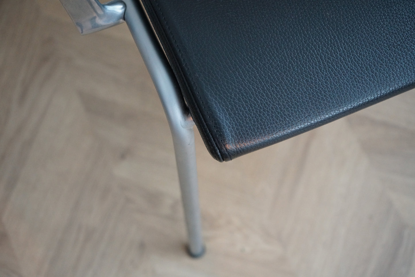 Close-up af Engelbrechts Chairik stol i sort læder med krom armlæn