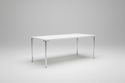 Engelbrechts hvidt spisebord set skråt med krom stel og bordplade 180×80 cm