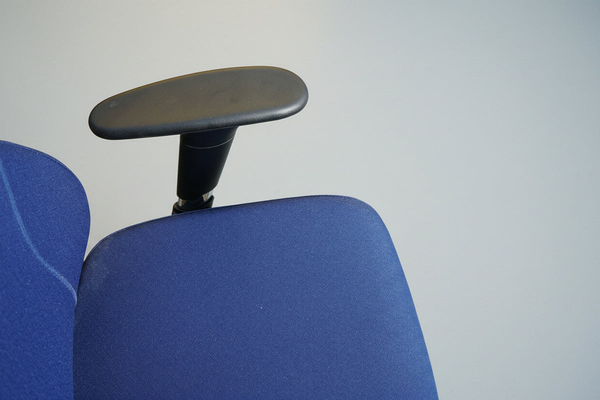 Close up af ergonomisk kontorstol med blå polstring og justerbare armlæn