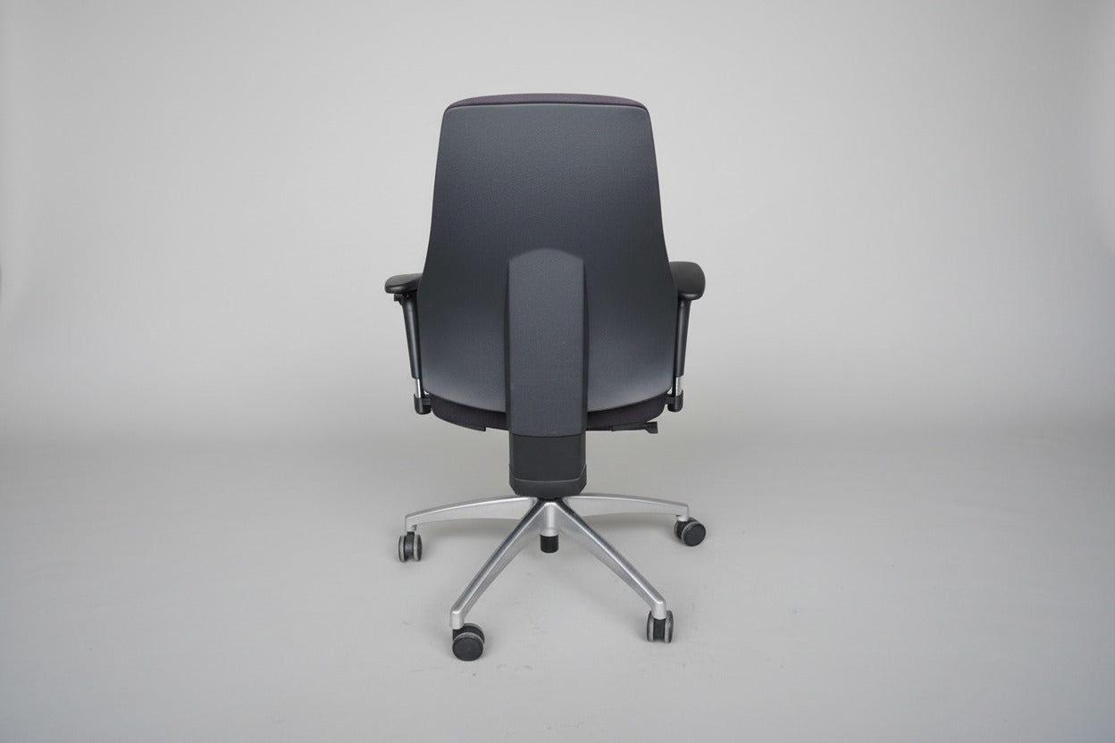 Ergonomisk kontorstol set bagfra med høj ryg, elegante kanalsyninger og poleret fodkryds med gummibanehjul.