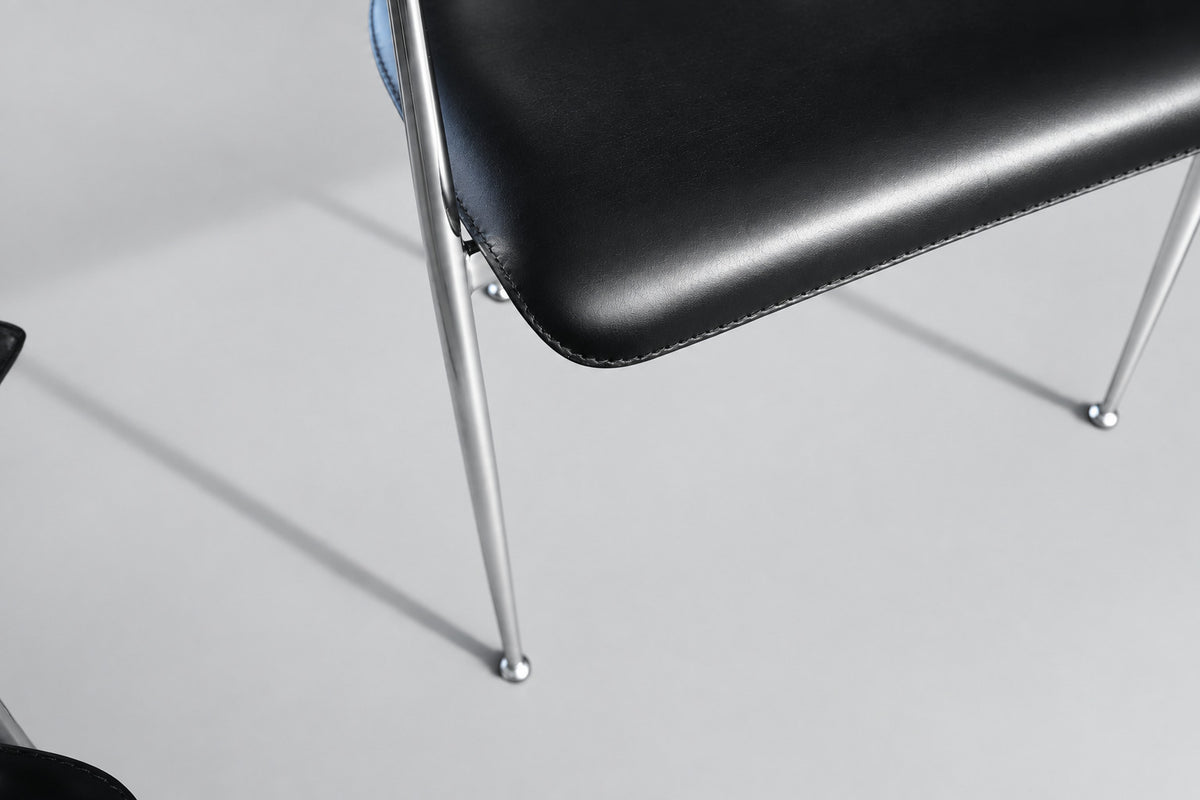 Nærbillede af Fasem P40 designstol med sort læderpolstring og detaljer i blankforkromet stål