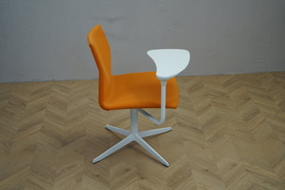 Four Design FourCast stol i orange set fra siden med drejbar skriveplade.