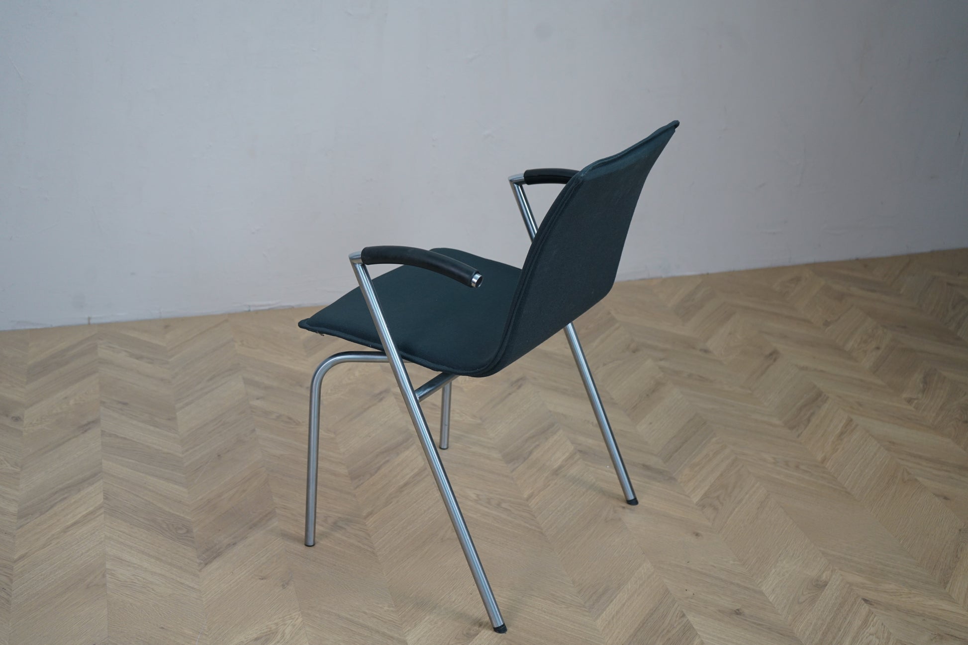 Skråbillede af Four Design G2 stabelbar konferencestol i mørkegrå med komfortabelt sæde og ryg