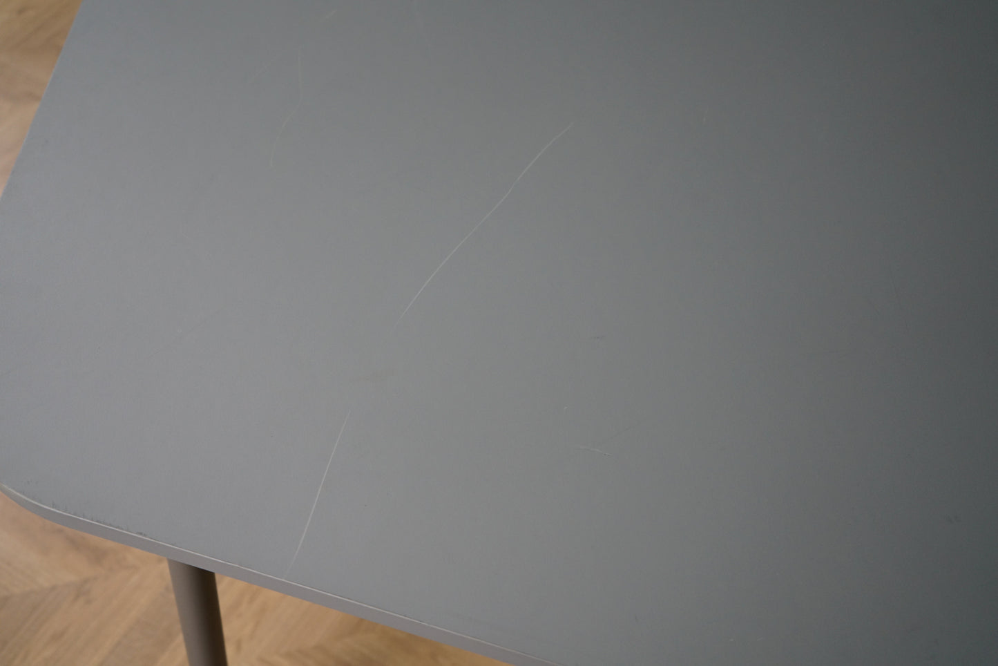 Overfladisk ridse på Four Design mødebord i grå laminat
