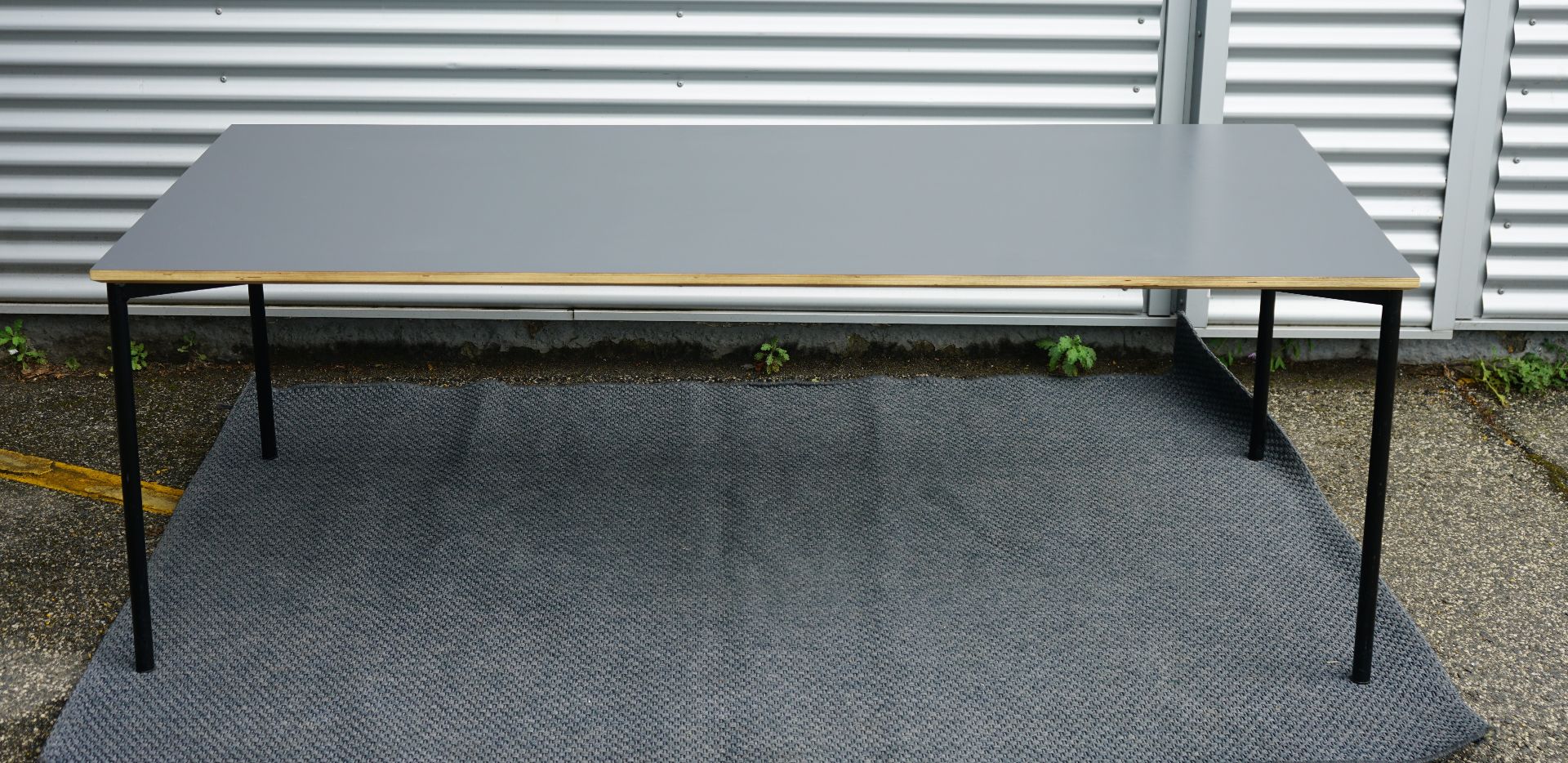 Fumac bord 210x90 i antracitgrå med flot bordplade og krydsfinerkanter set forfra.