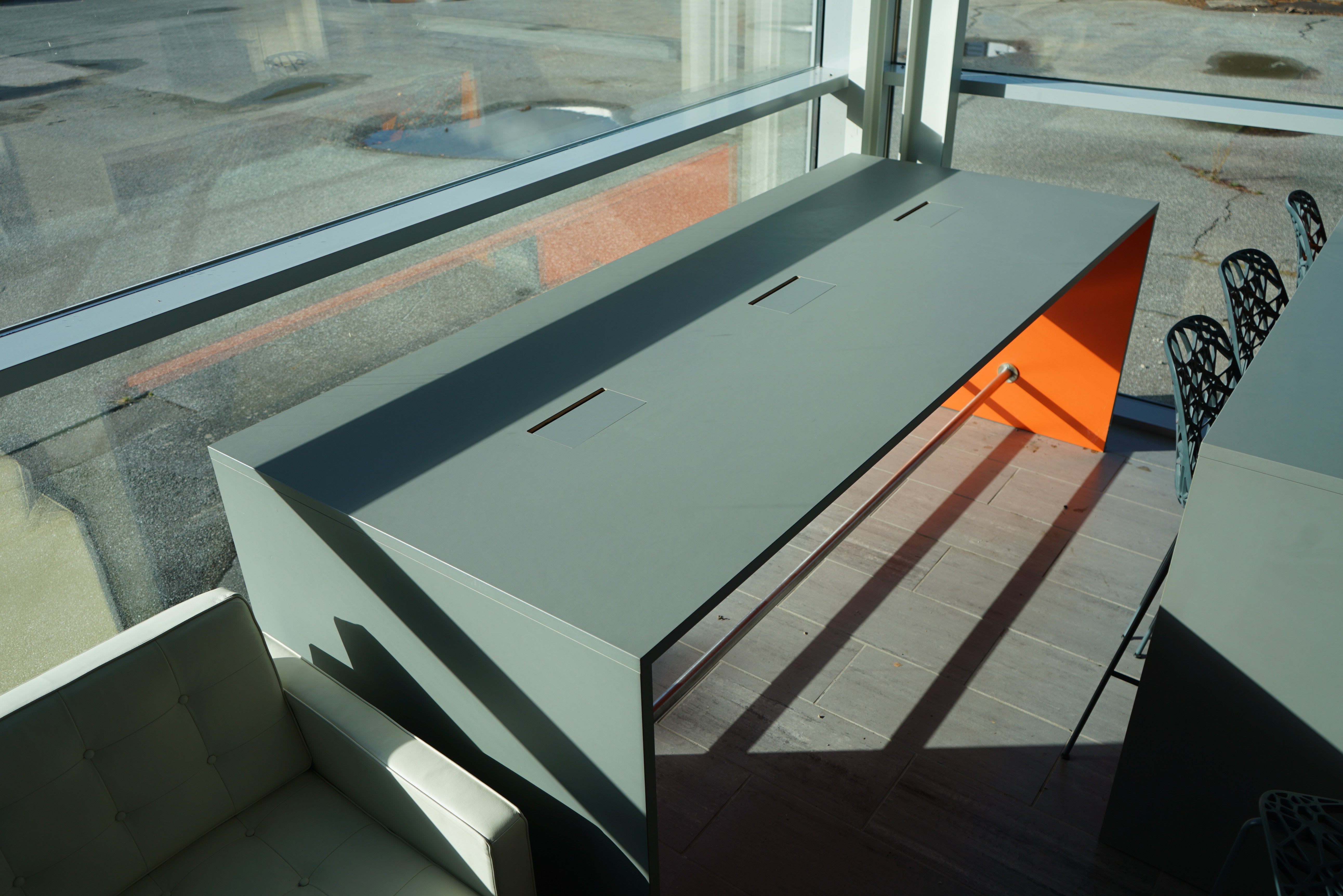 Fumac højbord i lysegrå linoleum med orange endestykke og kabelgennemføring.