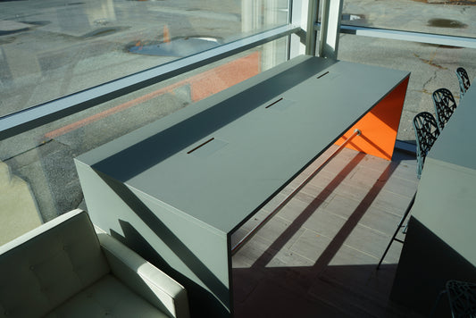 Fumac højbord i lysegrå linoleum med orange endestykke og kabelgennemføring.