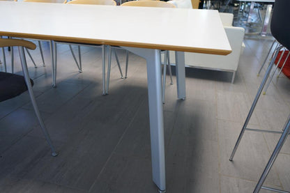 Nærbillede af Fumac bordets kant og laminatfinish – hvid bordplade i ét stykke med gråt stel i høj kvalitet.