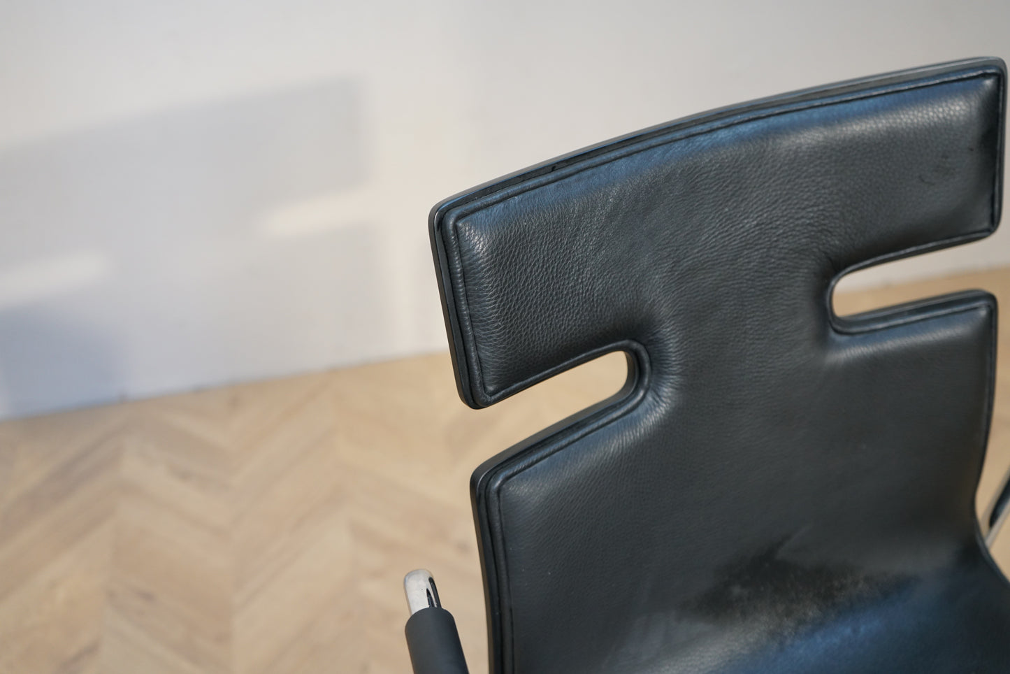 Close up af Fumac mødestol i sort med polstret sæde, ryglæn og armlæn.