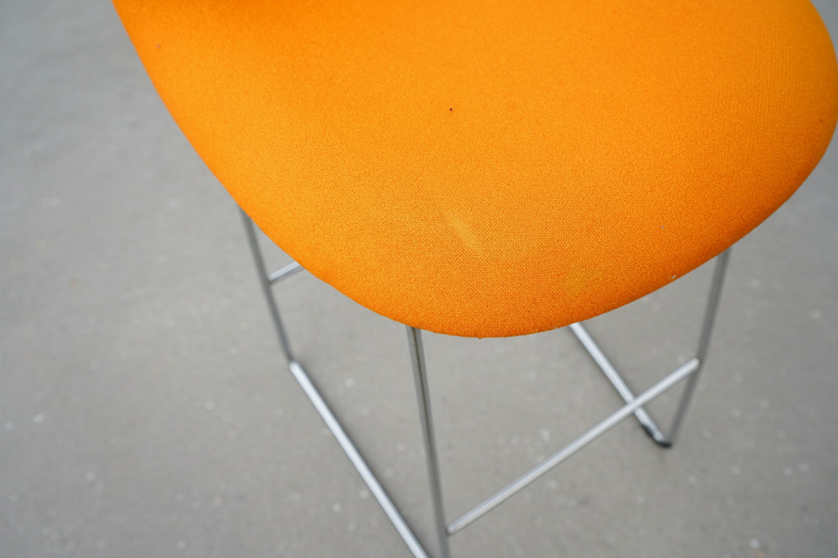 Close up af GUBI 3D barstol med orange polstret sæde og hvid plastbagside