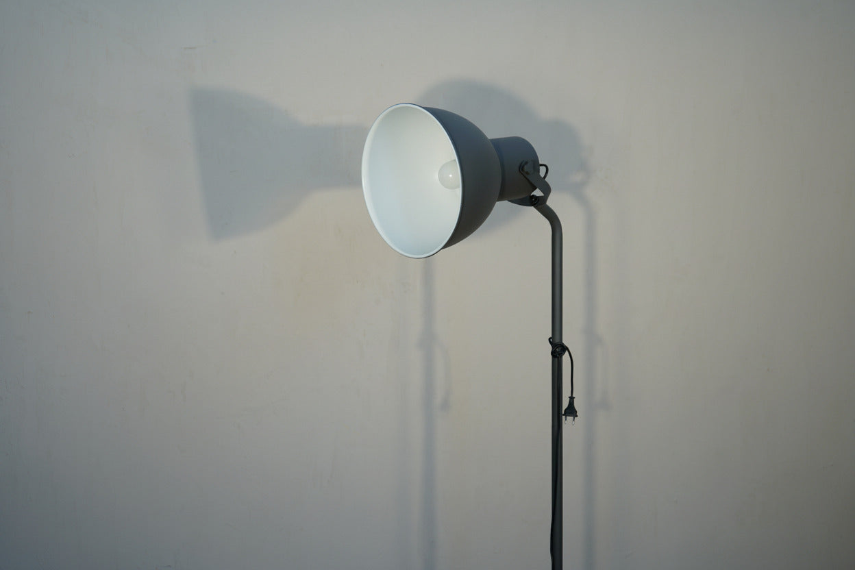 Close up af mørkegrå gulvlampe med justerbar lampeskærm.