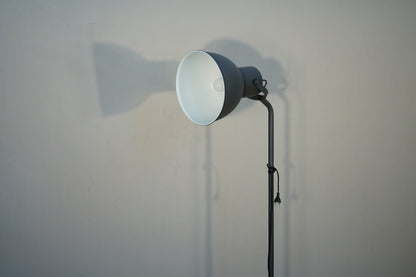 Close up af mørkegrå gulvlampe med justerbar lampeskærm.