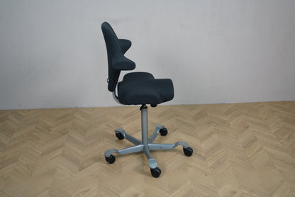 HÅG Capisco 8106 kontorstol i sort Fame vist fra siden med ergonomisk sadelsæde.