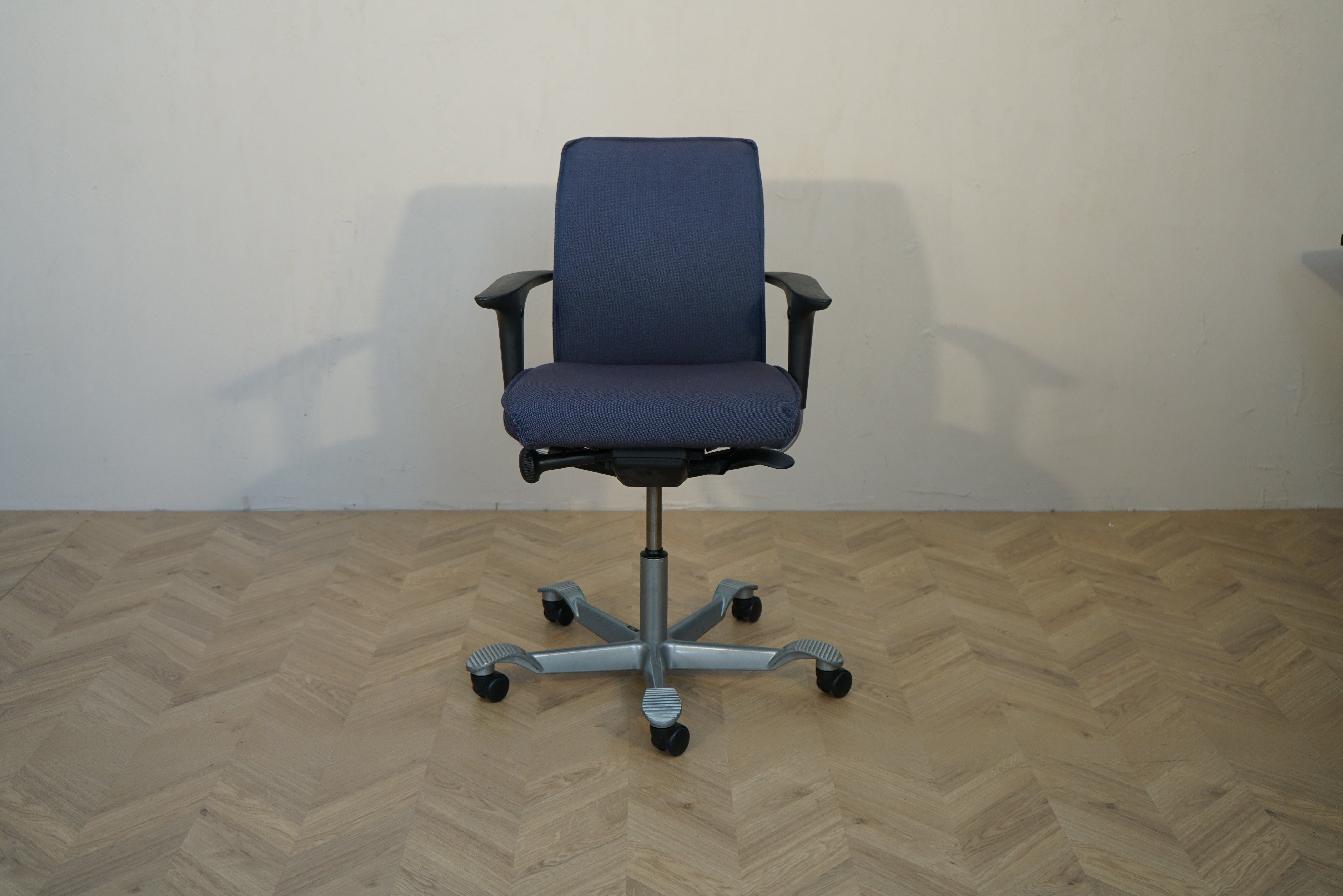 HÅG Creed ergonomisk kontorstol i mørkeblå polstring med armlæn set forfra
