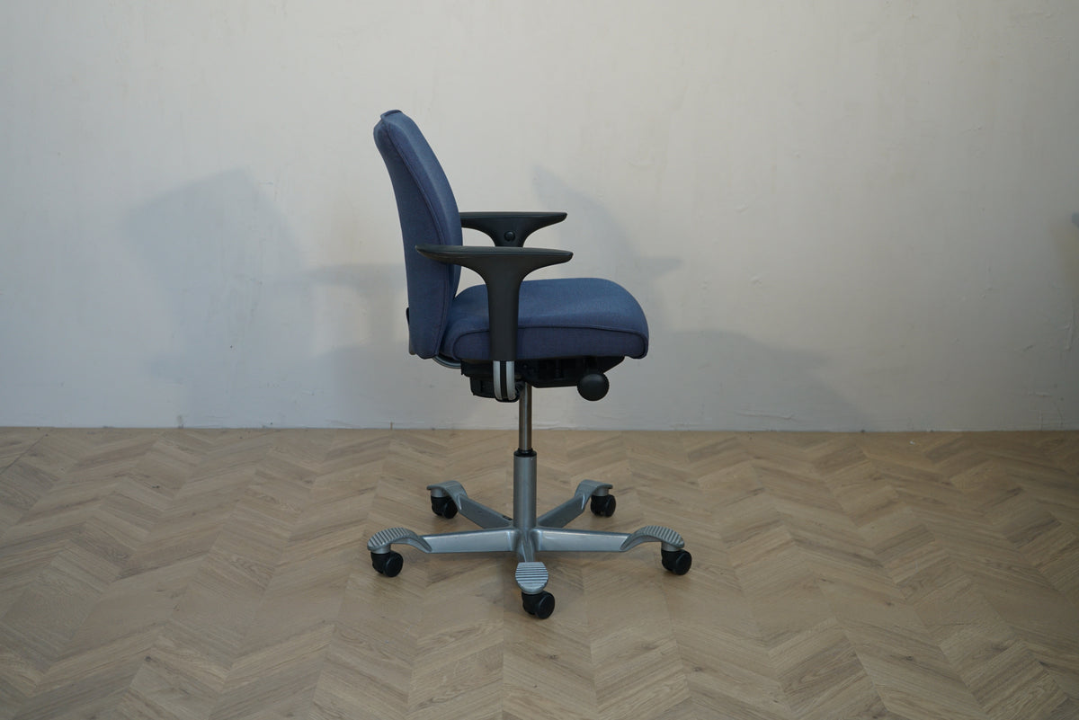 HÅG Creed ergonomisk kontorstol i mørkeblå polstring med armlæn set fra siden